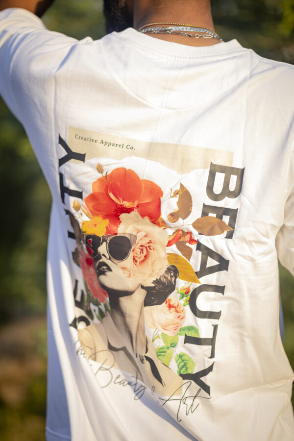 Back of a white T-shirt featuring a vintage-inspired woman’s portrait with floral elements and the word 'BEAUTY' in bold text.